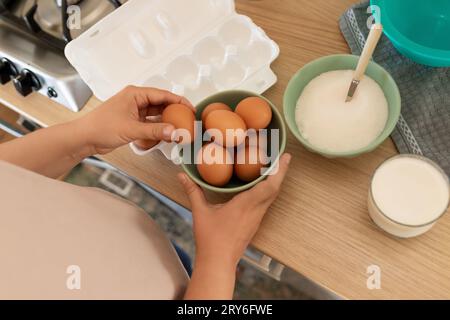 Die Hand zieht ein Ei heraus, um Rührei zu machen Stockfoto