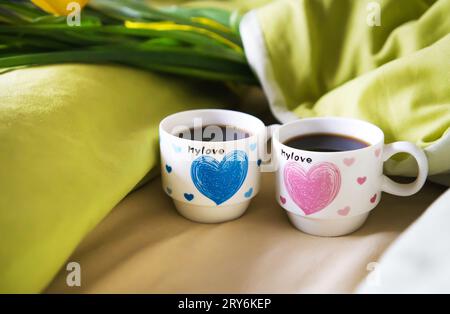 Zwei Tassen Kaffee stand auf dem Bett mit einem Blumenstrauß, close-up. Stockfoto