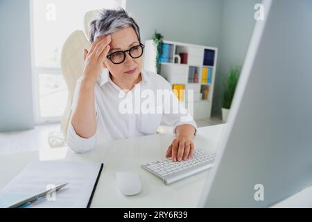 Foto von müder Burnout Dame Lehrer gekleidet weißes Hemd mit Kopfschmerzen bei der Arbeit moderne Gadget in der Werkstatt der Arbeitsstation Stockfoto