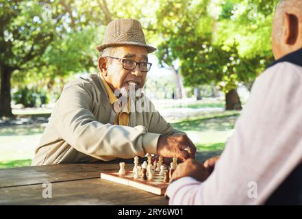 Spielen, Outdoor- und Seniorenfreunde für Schach, Strategie und Entspannung bei einem gemeinsamen Sport. Wettbewerb, Natur und ältere oder alte Menschen im Ruhestand mit Stockfoto