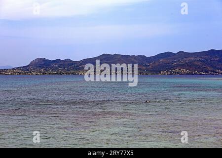 Blick auf die Insel Ägina von der Insel Agistri. Ein Mann schwimmt. Agistri, Saronische Inseln, Griechenland. Vom Juli 2023 Stockfoto