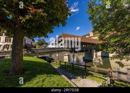 Die überdachte Berner Brücke überspannt die Saane in der Altstadt von Freiburg, Schweiz, eingerahmt von einem herbstlich gefärbten Kastanienbaum im Vordergrund. Sie stammt aus dem 13. Jahrhundert, und ihr heutiger Pfeiler und ihr heutiges Deck wurden 1853/54 neu erbaut. Sie ist die letzte erhaltene überdachte Brücke in der Stadt. Stockfoto