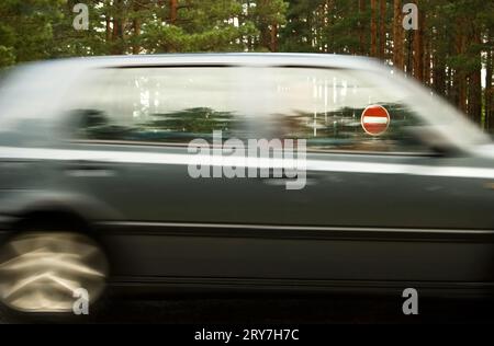 Das Verkehrsschild ist durch ein Fenster des vorbeifahrenden Autos verboten Stockfoto