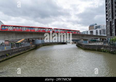 Der DLR-Zug der Docklands Light Railway überquert den Fluss Ravensbourne, auch bekannt als Deptford Creek, von der Ha'Penny Hatch Bridge in Deptford, South-East London, Großbritannien Stockfoto