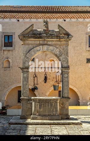 Der Kreuzgang, die Loggia aus dem 16. Jahrhundert und der mittelalterliche Platz mit dem monumentalen Brunnen im Heiligtum des Apostels San Matteo. Apulien Stockfoto