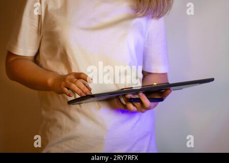 Frau digitale Malerin, die Pinsel hält und auf die Kamera schaut. Künstler bei der digitalen Arbeit. Junger digitaler Künstler, der zu Hause malte. Stockfoto