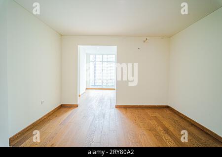 Das Zimmer ist sowohl gemütlich als auch geräumig, und es ist derzeit leer. Der Vinylboden verleiht dem Raum einen Hauch von Stil. Stockfoto