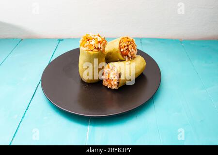 Gefüllte Zucchinihälften mit Hackfleisch, Reis und Gemüse auf einem schwarzen Teller, Seitenansicht aus der Nähe Stockfoto