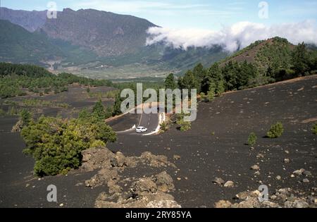 Fahrt mit dem Auto durch die vulkanische Landschaft mit üppigen grünen Kiefern, bunten Vulkanen und Lavafeldern am Pfad Ruta de los Volcanes in La P Stockfoto