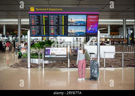 31.07.2023, Singapur, Republik Singapur, Asien - Air Traveller steht vor den Fluginformationsbildschirmen in der Abflughalle von Changi's T4. Stockfoto