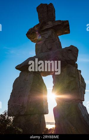 Silhouette von Inukshuk. Die Figur von Uukshuk an der Meeresküste gegen Sonnenuntergang. Inukshuk am English Bay Beach in Vancouver BC. Reisefoto, niemand Stockfoto