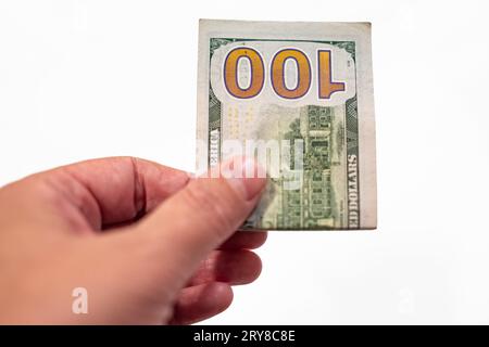 Hand hält hundert Dollar isoliert auf weißem Hintergrund. Mann oder Frau geben 100-Dollar-Scheine. 100 US Dollar in einer Hand. Währung exkl Stockfoto