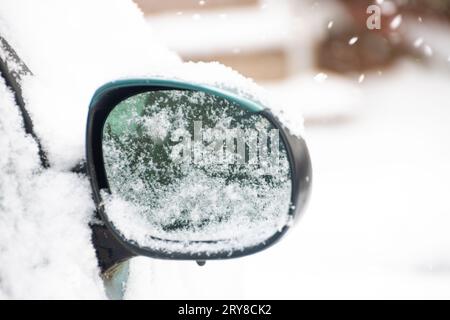Rückspiegel eines verschneiten Autos an einem Wintertag Stockfoto