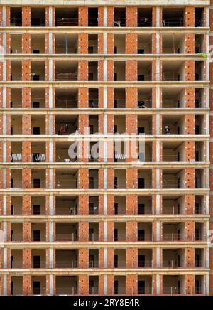 Vorderansicht einer großen Baustelle mit mehrstöckigem Wohngebäude im Bau. Stockfoto