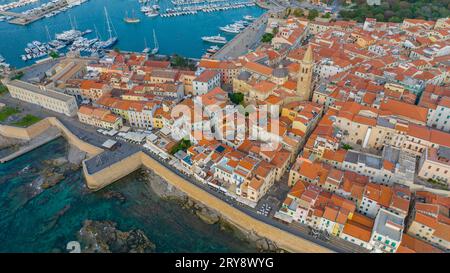 Blick aus der Vogelperspektive auf die Altstadt von Alghero auf Sardinien. Foto mit einer Drohne an einem sonnigen Tag. Panoramablick auf die Altstadt und den Hafen von Alghero, SAR Stockfoto