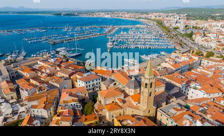 Blick aus der Vogelperspektive auf die Altstadt von Alghero auf Sardinien. Foto mit einer Drohne an einem sonnigen Tag. Panoramablick auf die Altstadt und den Hafen von Alghero, SAR Stockfoto