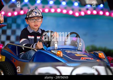 Junge, 3 Jahre, multiethnisch, eurasisch, fährt Auto, Kinderkarussell, Messegelände, Cannstatter Volksfest, Wasen, Cannstatt, Stuttgart Stockfoto