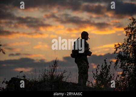 Hohenfels, Bayern, Deutschland. September 2023. Der Anführer der Infanterieregiment Justin Gerber, ein Anführer des 2. Kavallerieregiments, spricht im Radio von der Spitze eines Hügels, der als Old Baldie bekannt ist, bei Sonnenaufgang während der Saber Junction 23 im Joint Multinational Readiness Center bei Hohenfels, Deutschland, 15. September 2023. US-Soldaten schlafen und leben seit mehreren Wochen im Feldumfeld, während sie zusammen mit NATO-Truppen trainieren, um ihre Interoperabilitätsoperationen zu verbessern und ihre Kampfbereitschaft zu verbessern. Quelle: U.S. Army/ZUMA Press Wire/ZUMAPRESS.com/Alamy Live News Stockfoto