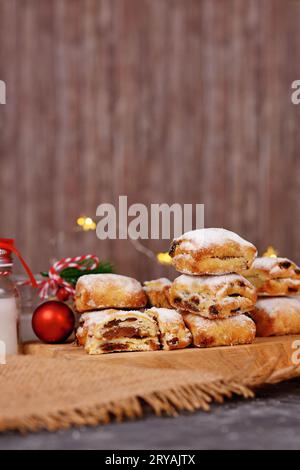 Kleine Stollen-Tortenstücke, ein deutsches Fruchtbrot mit Nüssen, Gewürzen und getrockneten Früchten mit Puderzucker, das traditionell während der Weihnachtszeit serviert wird Stockfoto
