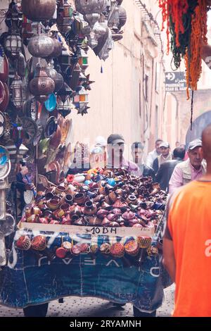 Ein einheimischer Mann schob im März 2012 einen Wagen mit Keramik- und Mischwaren durch die Souks in Marrakesch Marokko Stockfoto