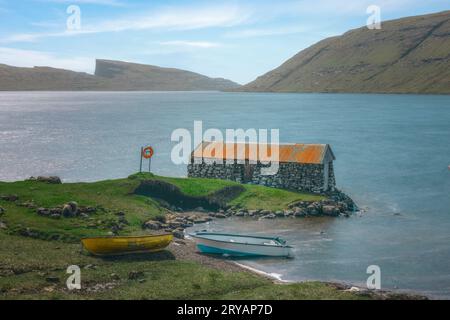 Traditionelle Bootshäuser am See Sørvágsvatn bei Sandavagur auf der Insel Vagar auf den Färöern Stockfoto