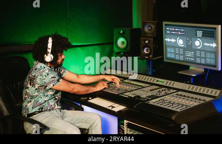 Junger Tontechniker, der im Musikstudio Klänge mixt - Jugendmusiker-Lifestyle-Konzept Stockfoto