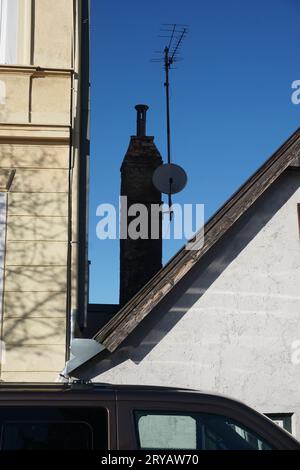 Altes Dach mit Satellitenschüssel auf Schornstein Stockfoto