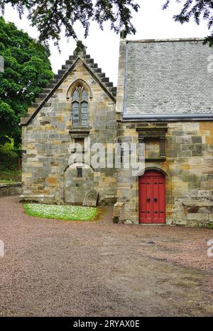 Teil der Old Parish Church, Culross, Schottland. Die hellrote Tür bietet einen markanten Kontrast zum mittelalterlichen Natursteinmauerwerk. Stockfoto