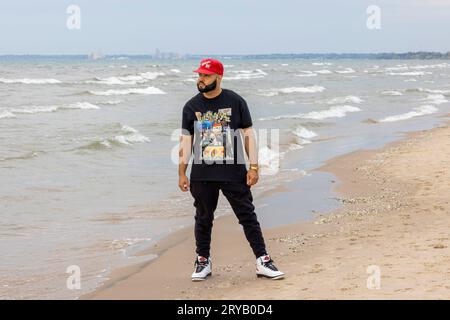 Ein Mann mit Bart ruht am Strand am See, während er Sport treibt Stockfoto