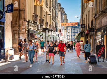 An einem sonnigen Samstagnachmittag schlendern die Leute an den Geschäften in der Grand Rue im Zentrum von Grenoble, Frankreich. Stockfoto