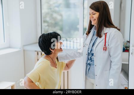 Erfahrener Arzt, der positive medizinische Ergebnisse mit einem zufriedenen älteren Patienten in einer Klinik untersucht und diskutiert Stockfoto