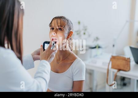 Ein Arzt untersucht die Kehle eines jungen Patienten in einer Klinik mit dem Videolaryngoskop. Stockfoto