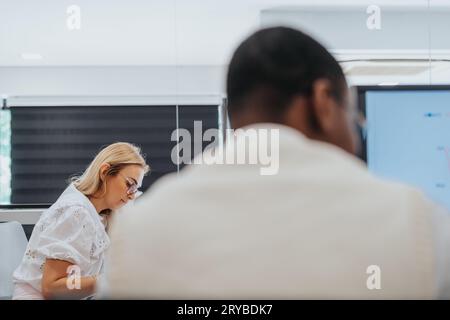 Selbstbewusste Geschäftsleute in einem Kreativbüro, die gemeinsam an der Analyse von Berichten, der Lösung von Problemen und der Entwicklung eines strategischen Erfolgsplans arbeiten. Stockfoto