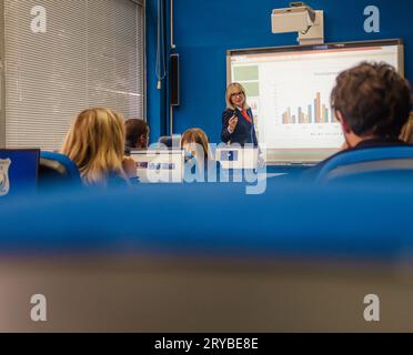 Erwachsenenprofessorin, die ihren Schülern die Präsentation im College-Klassenzimmer erklärt, E-Learning-Online-Schule Stockfoto