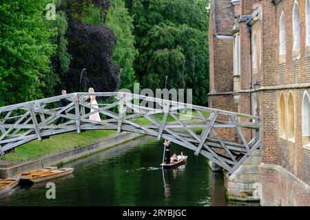 Cambridge, England – 20. Juni 2023: Ein frisch verheiratetes Paar feiert auf der Mathematical Bridge über den Fluss Cam Stockfoto