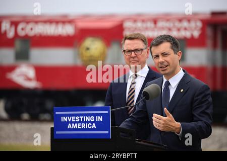 Lexington, Vereinigte Staaten von Amerika. 29. September 2023. Der US-Verkehrsminister Pete Buttigieg, rechts, äußert sich in einer Rede, während Jim Gray, der linke Verkehrsminister von Kentucky, auf die Ankündigung einer 8 Millionen Dollar teuren Förderung zur Ersetzung einer 86 Jahre alten Eisenbahnbrücke am Central Kentucky Rail Yard am 29. Juni 2023 in Lexington, Kentucky, schaut. Kredit: USDOT/US Department of Transportation/Alamy Live News Stockfoto