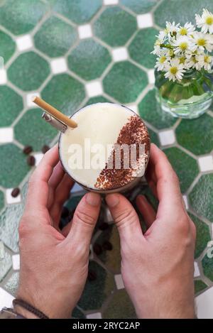 Hände halten vietnamesischen gesalzenen Kaffee mit salziger Käsesahme (Ca phe muoi) Stockfoto
