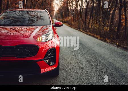 12-11-2021 Trencin, Slowakei schönes und modernes rotes SUV-Auto auf der Straße mit Blinker - Wald hinter dem Hintergrund bei Sonnenuntergang. Neues rotes Auto auf der Straße - pho Stockfoto