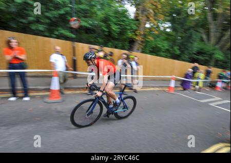 Radfahrer verschwimmen den Hintergrund, während sie die Swains Lane, Highgate, London, Großbritannien in der London Cycling Campaign Urban Hill Climb beschleunigen. Die Veranstaltung ist ein flaches Rennen auf der steilsten Straße Londons, und neben Alters- und Geschlechterkategorien gibt es Wettbewerbe für Falt- und Lastenräder. Swain’s Lane ist der berühmteste und berüchtigtste Aufstieg in London. Die Fahrspur ist ein extrem steiler Abschnitt zwischen Hampstead Heath und Highgate Cemetery mit einem Gefälle von durchschnittlich 9 % über 0,6 km, das sich aber in der Nähe der Bergspitze auf 14 % erhöht. Stockfoto