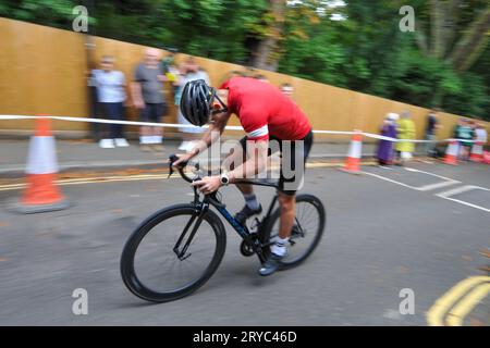 Radfahrer verschwimmen den Hintergrund, während sie die Swains Lane, Highgate, London, Großbritannien in der London Cycling Campaign Urban Hill Climb beschleunigen. Die Veranstaltung ist ein flaches Rennen auf der steilsten Straße Londons, und neben Alters- und Geschlechterkategorien gibt es Wettbewerbe für Falt- und Lastenräder. Swain’s Lane ist der berühmteste und berüchtigtste Aufstieg in London. Die Fahrspur ist ein extrem steiler Abschnitt zwischen Hampstead Heath und Highgate Cemetery mit einem Gefälle von durchschnittlich 9 % über 0,6 km, das sich aber in der Nähe der Bergspitze auf 14 % erhöht. Stockfoto