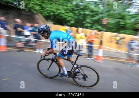 Radfahrer verschwimmen den Hintergrund, während sie die Swains Lane, Highgate, London, Großbritannien in der London Cycling Campaign Urban Hill Climb beschleunigen. Die Veranstaltung ist ein flaches Rennen auf der steilsten Straße Londons, und neben Alters- und Geschlechterkategorien gibt es Wettbewerbe für Falt- und Lastenräder. Swain’s Lane ist der berühmteste und berüchtigtste Aufstieg in London. Die Fahrspur ist ein extrem steiler Abschnitt zwischen Hampstead Heath und Highgate Cemetery mit einem Gefälle von durchschnittlich 9 % über 0,6 km, das sich aber in der Nähe der Bergspitze auf 14 % erhöht. Stockfoto