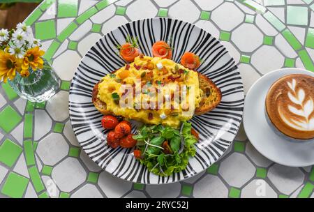 Toast mit Rührei, Kürbispüree und Würfeln, geräuchertem Lachs und Kürbiskernen Stockfoto