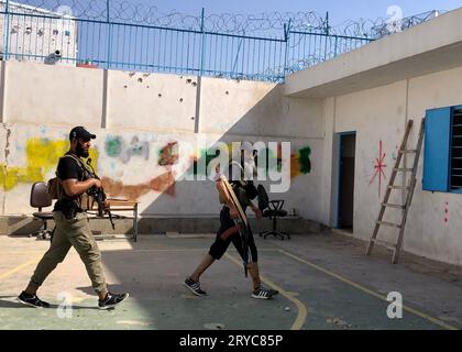 Beirut, Libanon. September 2023 29. Dieses Foto, das mit einem Mobiltelefon aufgenommen wurde, zeigt bewaffnete Militante, die am 29. September 2023 aus einer UN-Flüchtlingshochschule im Ain Al-Helweh-Lager im Südlibanon ausscheiden. Bewaffnete Militante zogen sich am Freitag aus den acht Schulen des Hilfswerks der Vereinten Nationen für Palästinaflüchtlinge (UNRWA) im Lager Ain Al-Helweh im Südlibanon zurück, berichtete die nationale Nachrichtenagentur (NNA).nach Angaben der NNA eine gemeinsame palästinensische Sicherheitstruppe war dort, um den Rückzug zu überwachen und sicherzustellen, dass es nicht zu Sicherheitsvorfällen kommt. Kredit: Ali Hashisho/Xinhua/Alamy Live News Stockfoto