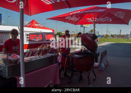 Coca Cola Offizielle grillveranstaltung, bei der junge Männer Gerichte vom Grill zubereiten und servieren Stockfoto