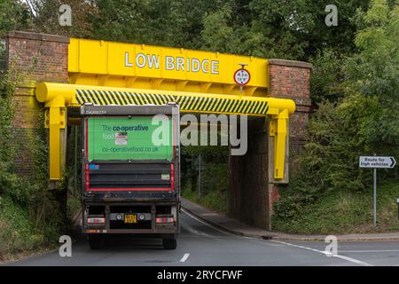 Eine Eisenbahnbrücke, die häufig von Lastkraftwagen getroffen wird, die kürzlich hellgelb gestrichen wurden, Wrecclesham, Surrey, England, Großbritannien. Niedrige Brücke Stockfoto