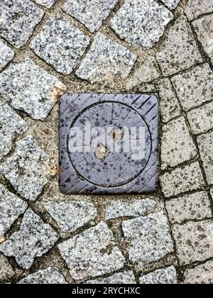 Schachtabdeckung des Gaspipelinesystems. Eine massive Metallluke für den Zugang zur Stadtkommunikation auf dem Bürgersteig. Stockfoto