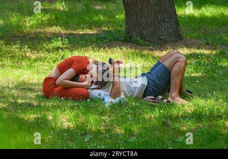 Ein Paar auf dem Gras im Park der Villa Borghese an einem sonnigen Tag, Rom Stockfoto