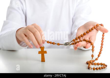 Latin Boy hält Rosenkranzperlen mit beiden Händen Stockfoto