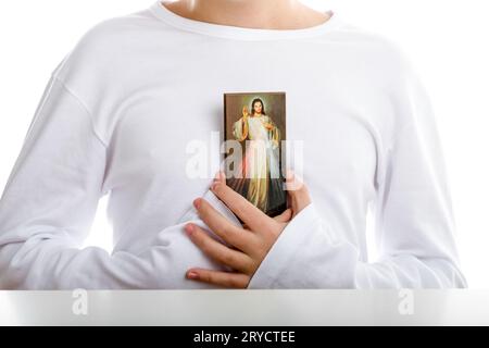 Hispanischer Junge mit der Ikone des barmherzigen Jesus Stockfoto