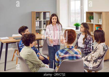 Gruppe von Schuljungen und Mädchen, die über etwas im Klassenzimmer diskutieren Stockfoto